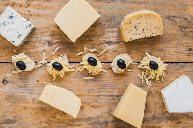 Eine obenliegende Ansicht von Käseblöcken mit Minisandwichen auf Holzoberfläche
