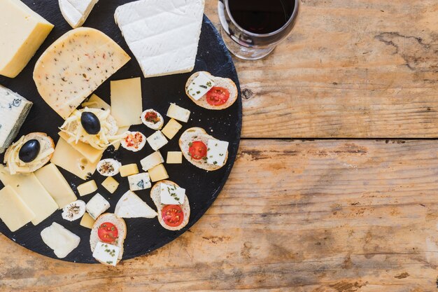 Eine obenliegende Ansicht von Minisandwichen mit Käse und Tomaten auf hölzernem Schreibtisch