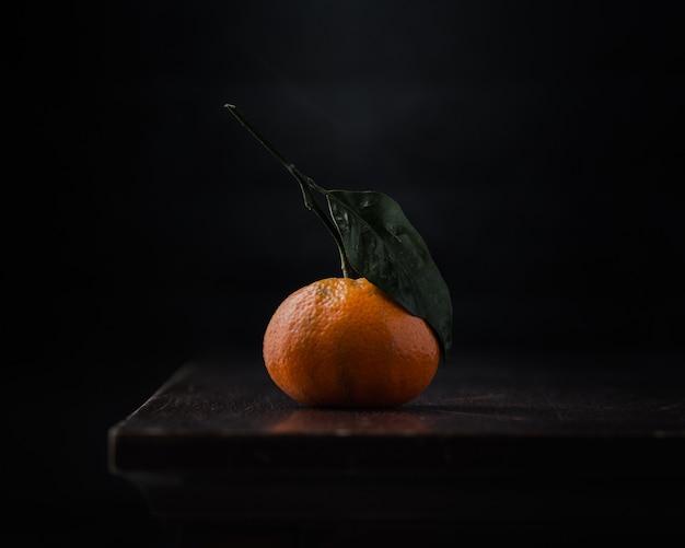 Eine Orange auf schwarzem Tisch