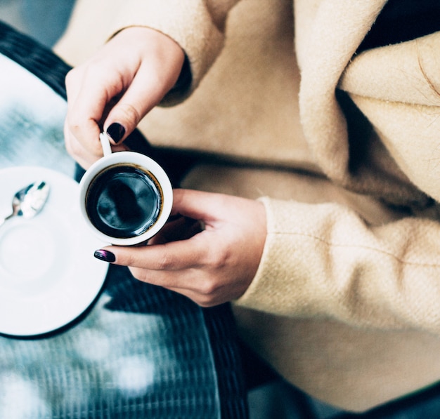 Eine Person, die eine Tasse Kaffee hält