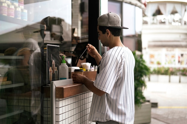 Eine person, die im straßencafé der stadt essen und kaffee kauft? Premium Fotos