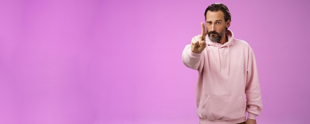 Eine Regel, hör zu, seriös aussehender, herrisch fokussierter, entschlossener erwachsener bärtiger Mann in rosa Kapuzenpulli