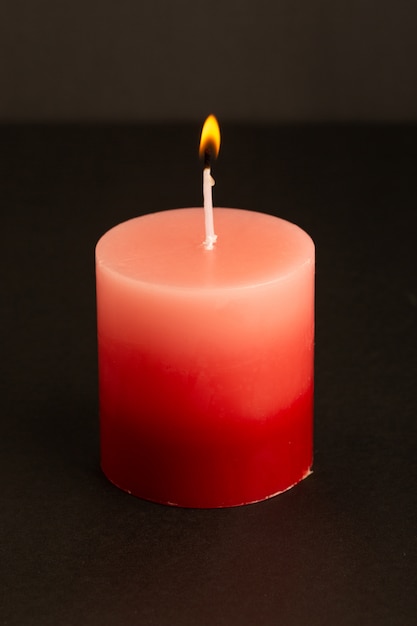 Eine rote Kerzenbeleuchtung der Vorderansicht isolierte schmelzendes Lichtfeuerflamme