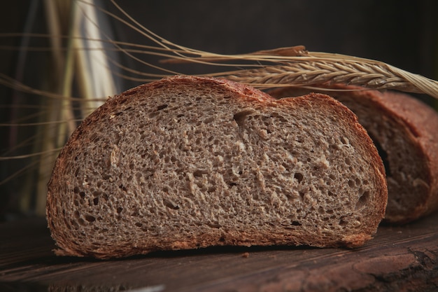 Eine Scheibe Brot auf einem Schneidebrett und dunkelbraune Nahaufnahme