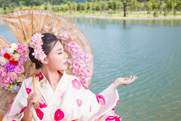 Eine schöne asiatische Frau, die einen japanischen Kimono, traditionelles Kleidkonzept trägt.