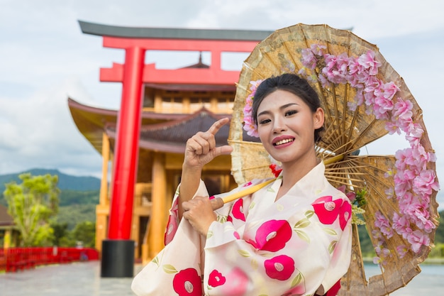 Kostenloses Foto eine schöne asiatische frau, die einen japanischen kimono, traditionelles kleidkonzept trägt.