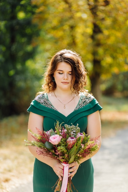 eine schöne Braut, die grünes Hochzeitskleid trägt