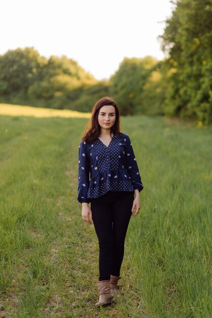 Eine schöne junge Frau, die im Wald geht