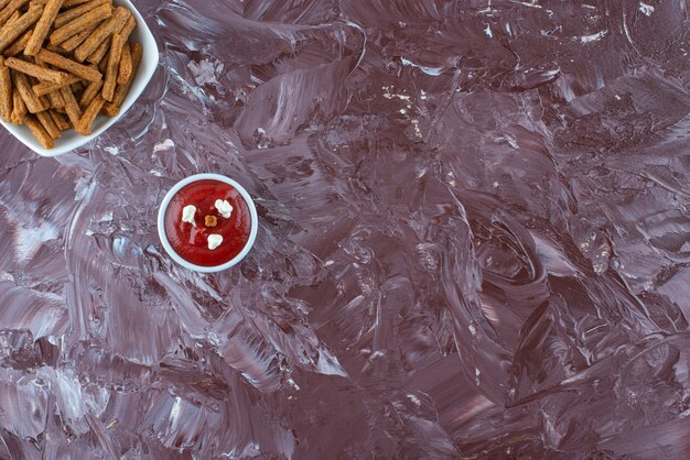 Eine Schüssel Ketchup und knusprige Semmelbrösel in einer Schüssel auf dem Marmortisch.