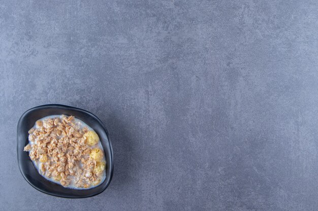 Eine Schüssel leckeres Müsli auf blauem Hintergrund. Foto in hoher Qualität