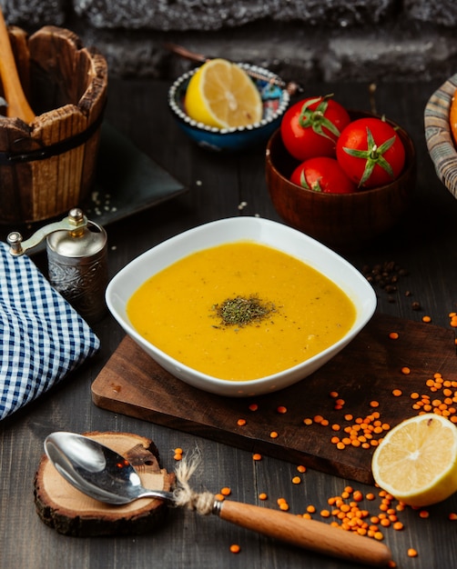 eine Schüssel Linsensuppe auf schwarzem Holztisch