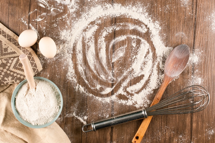 Kostenlose Foto eine schüssel mehl mit eiern und holzlöffel