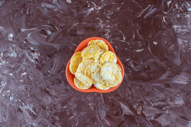 Kostenloses Foto eine schüssel mit leckeren käsechips auf dem marmortisch.