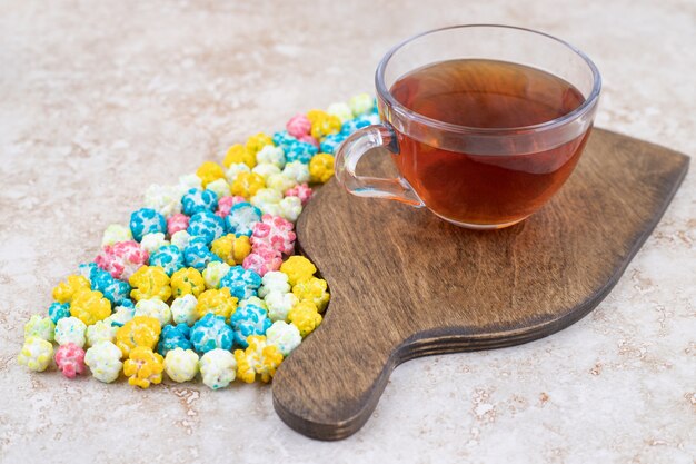 Eine tasse heißen tee mit bunten bonbons