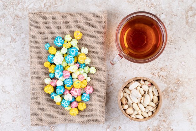 Eine Tasse heißen Tee mit bunten Bonbons