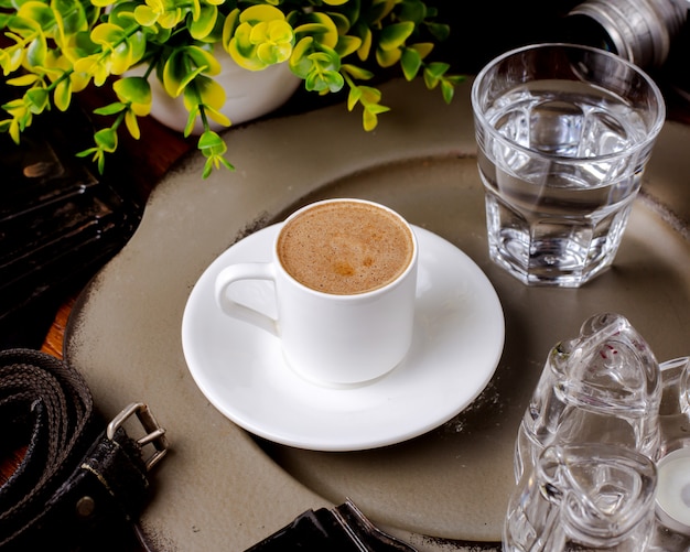 Eine Tasse heißes Americano und ein Glas Wasser