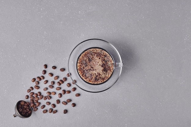 Eine tasse kaffee auf grauem hintergrund.