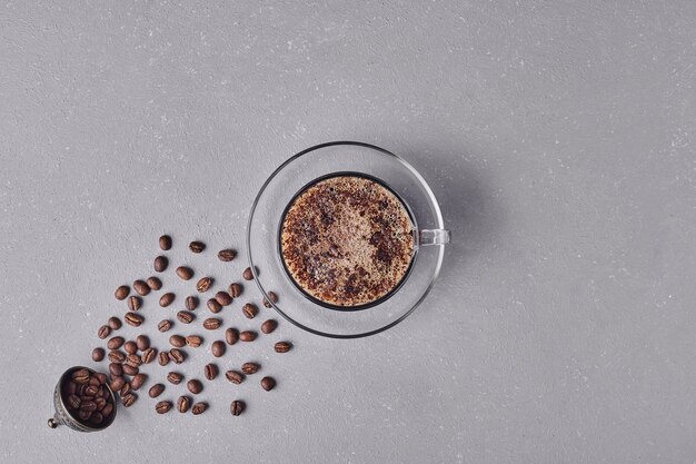 Eine Tasse Kaffee auf grauem Hintergrund.