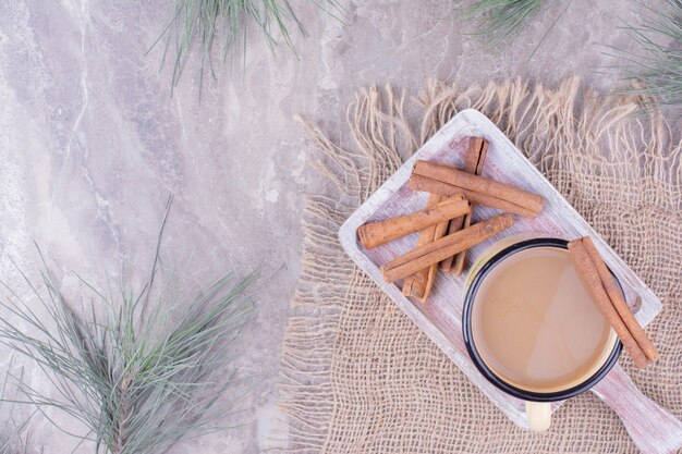 Eine Tasse Kaffee mit Zimtgeschmack auf einem Holzbrett