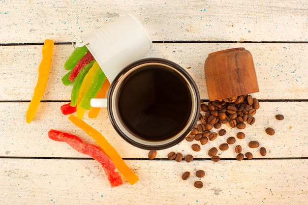 Eine Tasse Kaffee von oben mit frischen braunen Kaffeesamen und bunter Marmelade