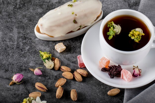 Eine Tasse Tee mit Nüssen und milchig cremigem Kuchen