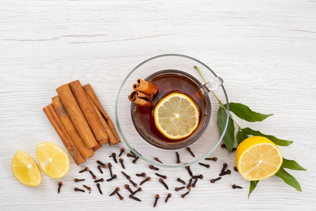 Eine Tasse Tee von oben mit Zitronenminze und Zimt auf weißem Tee-Dessert-Bonbon