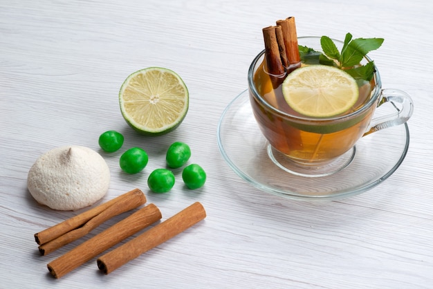 Eine Tasse Tee von oben mit Zitronenplätzchen und Zimt auf weißem Tee-Dessertbonbon