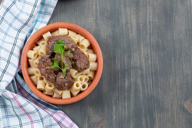 Eine Tonschale mit leckeren Makkaroni und Fleisch