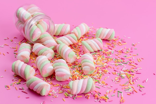 Eine Vorderansicht, die Marshmallows kaut, alles auf Rosa, mit Süßigkeitspartikeln, die Regenbogenzuckerkonfiguration färben
