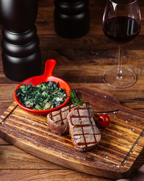 Eine Vorderansicht gebratenes Fleisch mit Soße und Gemüse zusammen mit einem Glas Wein auf dem braunen Schreibtisch Essen Fleisch Mahlzeit