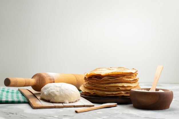 Eine Vorderansicht köstliche runde Pfannkuchen mit Mehl und Teigpfannkuchengebäckkochen