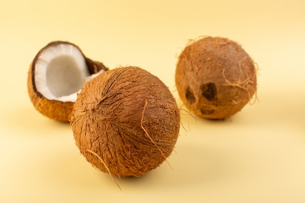 Eine vordere geschlossene Ansicht Kokosnüsse ganz milchig frisch weich auf dem cremefarbenen Hintergrund tropische exotische Frucht Nuss isoliert