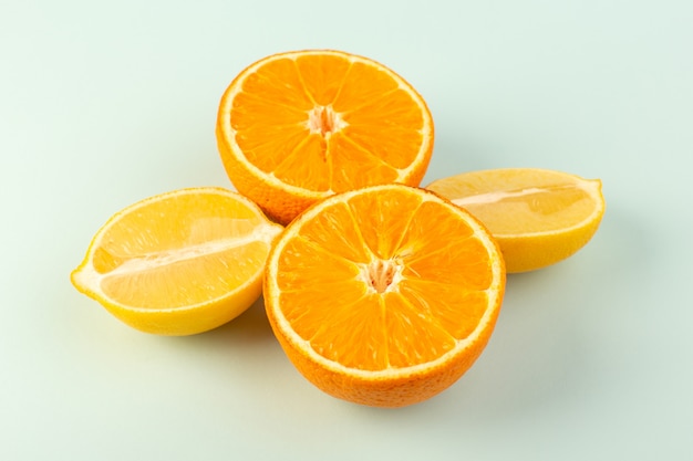 Eine vordere geschlossene Ansicht schnitt orange frisch reife saftige milde isolierte halb geschnittene Stücke zusammen mit geschnittenen Zitronen