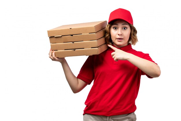 Eine weibliche Kurierin der Vorderansicht weiblicher Arbeiter des Lebensmittellieferservices hält Pizzaschachteln der Lebensmittellieferung auf Weiß
