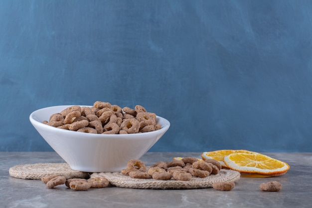 Eine weiße Schüssel mit gesunden Schokoladen-Müsliringen zum Frühstück.