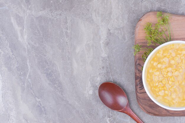 Eine weiße Tasse Erbsenbohnensuppe auf einer Holzplatte