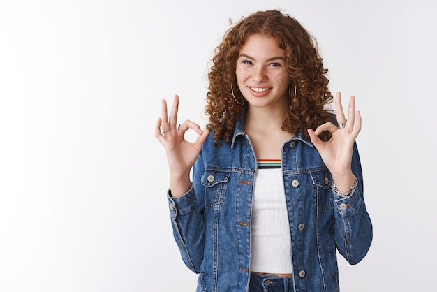 Einfach okay Portrait selbstbewusst durchsetzungsfähig gutaussehend rothaariges Mädchen Sommersprossen Pickel tragen Jeansjacke zeigen ok Geste Rate Freund Outfit stimme zu, das Produkt zu mögen, das auf weißem Hintergrund steht