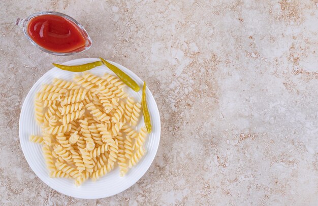 Einfaches Abendessen mit Mahlzeit und Dressing auf Marmorhintergrund.