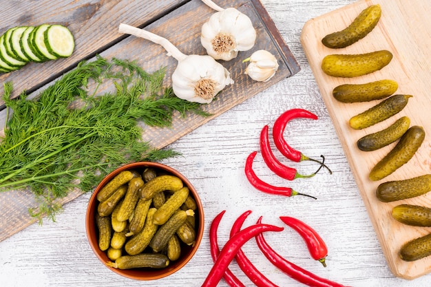 Eingelegte Gurke eingelegt und frisch mit Chili-Knoblauch und Dill auf weißem Holz