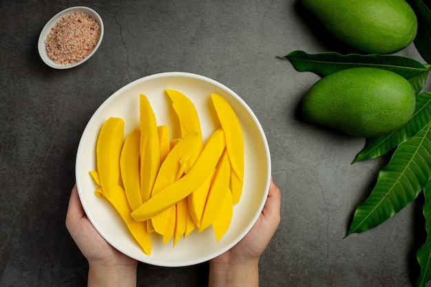 Eingelegte Mango auf dunkler Holzoberfläche