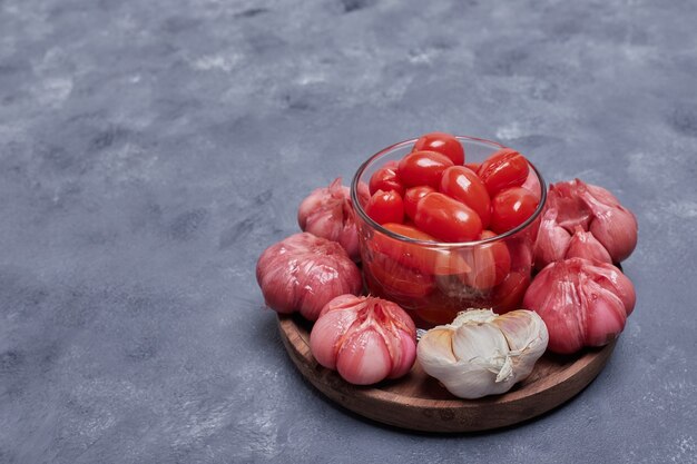 Eingelegte Tomaten und Knoblauch auf Holzteller.