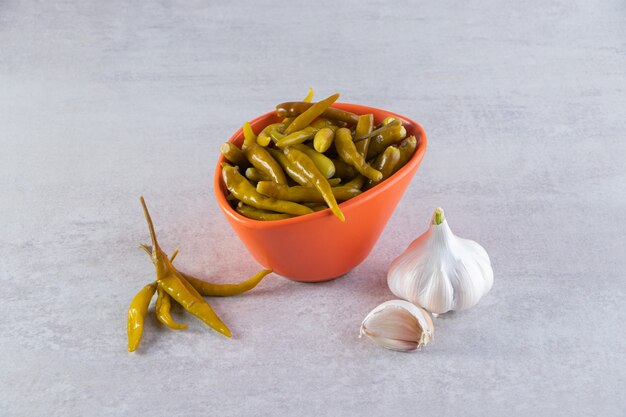 Eingelegter Chili-Pfeffer auf eine Steinoberfläche gelegt.