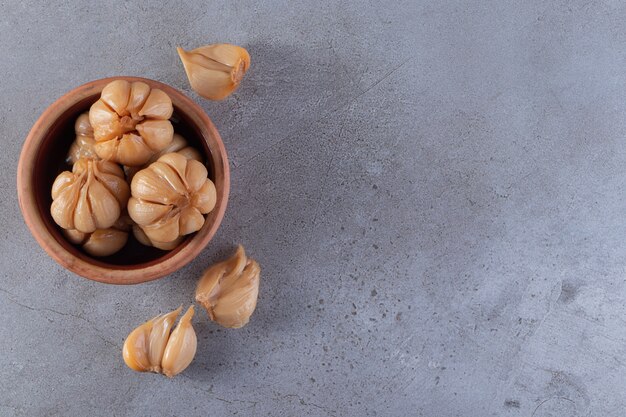 Eingelegter Knoblauch auf Steinhintergrund gelegt.