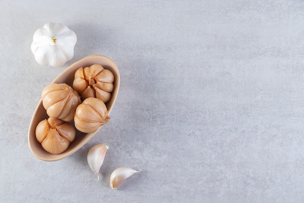 Eingelegter Knoblauch auf Steinhintergrund gelegt.