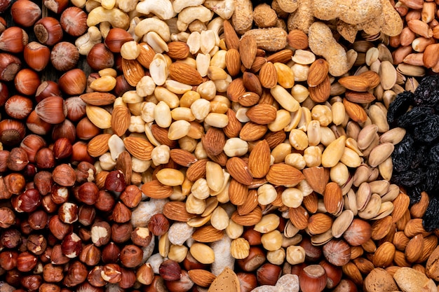 Kostenloses Foto einige der verschiedenen nüsse und getrockneten früchte mit pekannuss, pistazien, mandeln, erdnüssen, cashewnüssen, pinienkernen draufsicht.