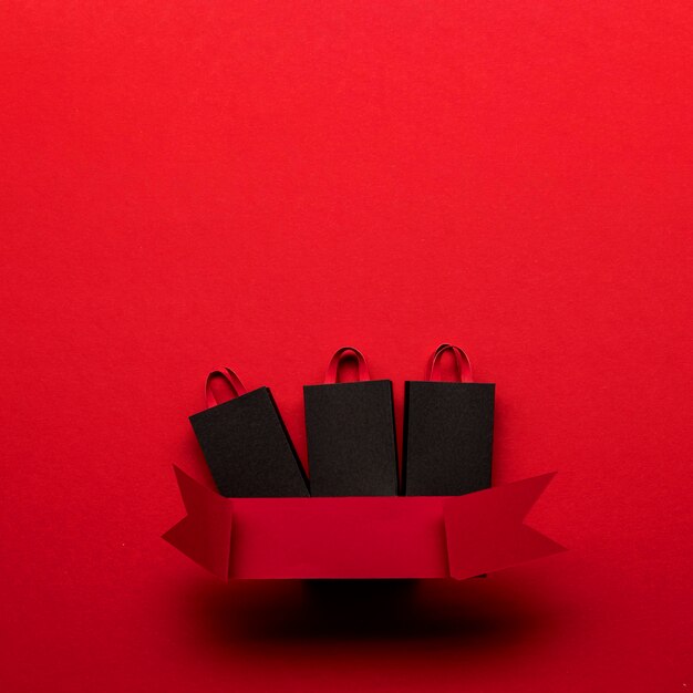 Einkaufstaschen und rotes Band schwarzer Freitag Konzept