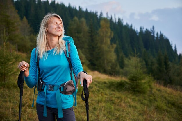 Einsame junge Frau, die im Sommer in frischer Bergluft wandert