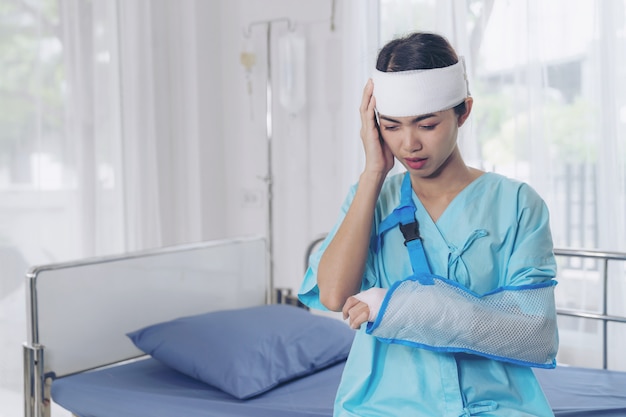 Einsame Unfallpatienten verletzen Kopfschmerzfrau im Krankenhaus - medizinisches Konzept