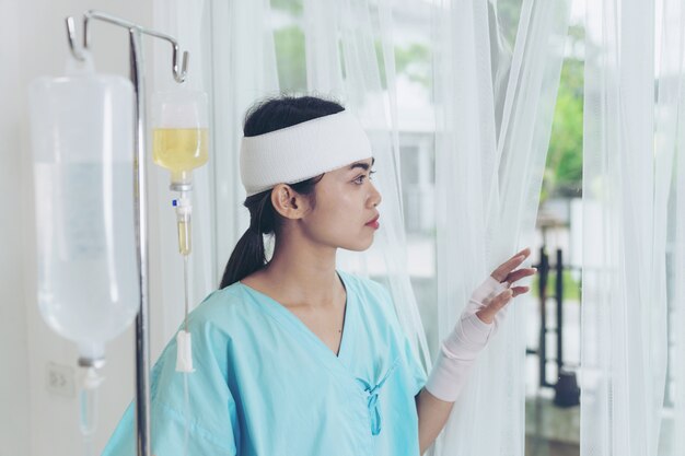 Einsame Unfallpatienten Verletzungsfrau auf Bettpatienten im Krankenhaus wollen nach Hause gehen - medizinisches Konzept