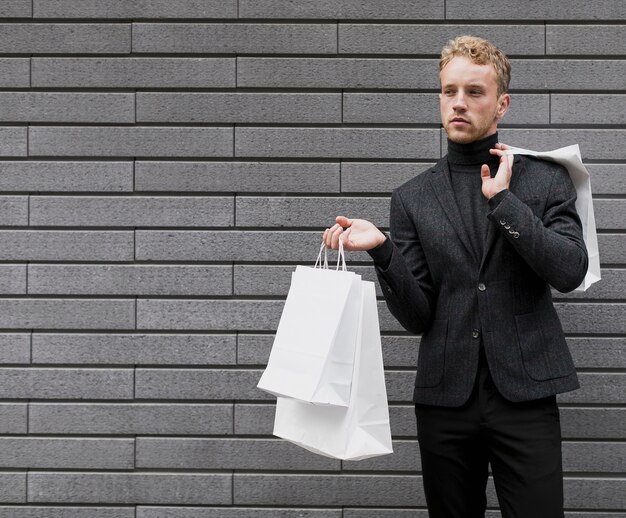 Einsamer junger Mann mit Einkaufstüten